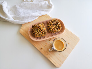 Coffee and muffins with crumble topping on wooden board