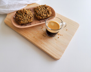Coffee and muffins with crumble topping on wooden board