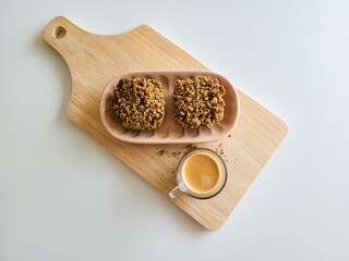 Coffee and muffins with crumble topping on wooden board
