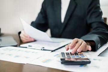 The businessman hand sits at their desks and calculates financial graphs showing the results of their investments planning the process of successful business growth