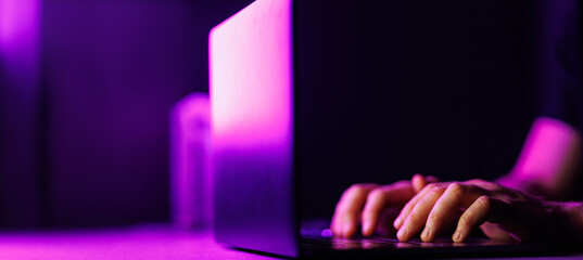 Man hands and Laptop on modern purple color environment. Copy space on black background.