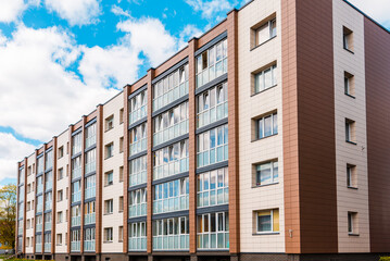 A newly renovated residential building apartments.Gray,brown block of flats.Newly finished modern style apartment building in freshly renovated residential area.Sunny summer day.