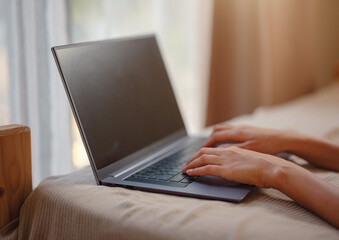 Happy young asian woman with laptop resting in bedroom in tiny house, weekend away and remote office idea. Tiny houses and Small Living concept.