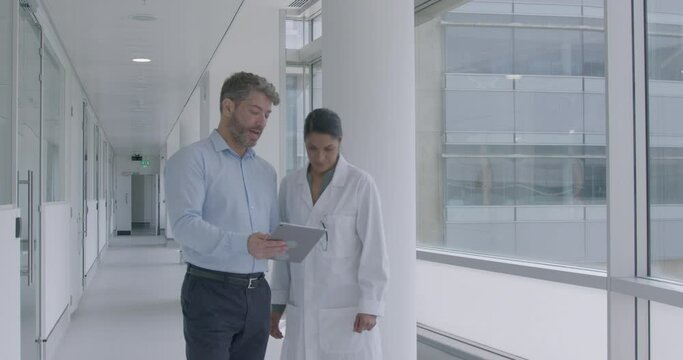 Doctors and Sales Representative Meeting in Hospital and looking at Digital tablet