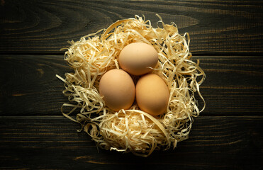 Three chicken eggs in a nest on a farm. The idea for the preparation of products for the egg diet...