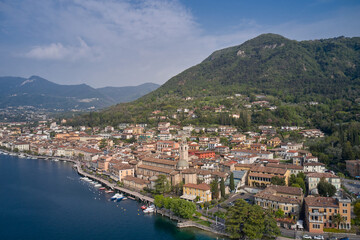Fototapeta na wymiar Lake in the mountains of Italy. Aerial view of the town on Lake Garda. View of the historic part of Salò on Lake Garda Italy. Tourist site on Lake Garda.