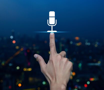 Hand pressing microphone flat icon over blur colorful night light modern city tower and skyscraper, Business communication concept