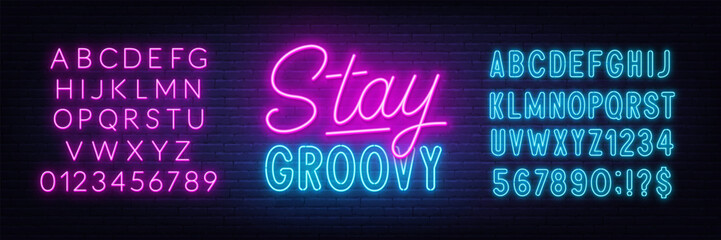 Fototapeta na wymiar Stay Groovy neon lettering on brick wall background.