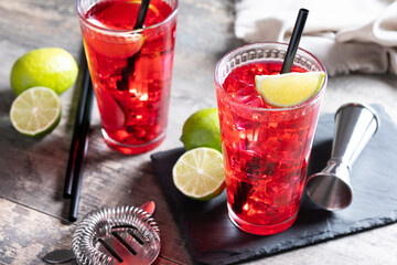 Cape Codder cocktail with vodka, cranberry juice and lime on wooden table