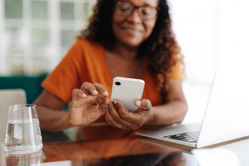 Senior woman using a smartphone to connect with her team in a hybrid work model