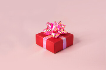 One red gift box on pink background still life.