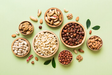 Fototapeta na wymiar mixed nuts in wooden bowl. Mix of various nuts on colored background. pistachios, cashews, walnuts, hazelnuts, peanuts and brazil nuts