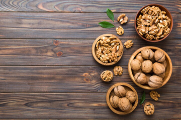Obraz na płótnie Canvas Walnut kernel halves, in a wooden bowl. Close-up, from above on colored background. Healthy eating Walnut concept. Super foods with copy space