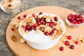Healthy breakfast food with granola, yogurt, fruits and nuts. Dessert parfait with dried fruits for breakfast