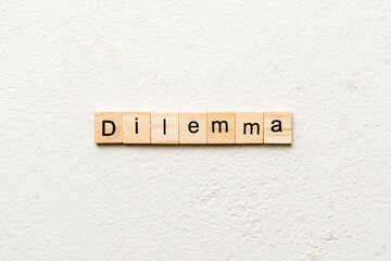 Dilemma word written on wood block. Dilemma text on cement table for your desing, concept