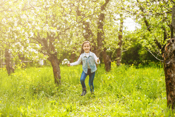 Beautiful little girl near the blossom tree