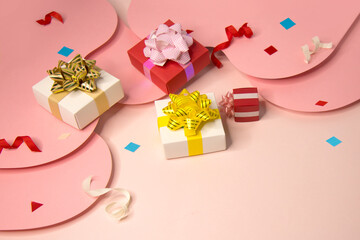 Luxury gift boxes and empty gift card on pink coloured background still life.