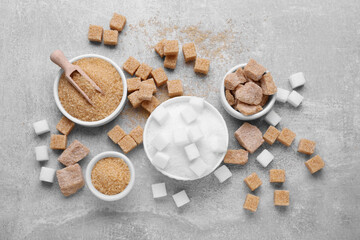 Different types of sugar on grey table, flat lay