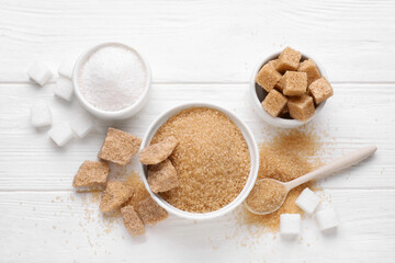 Different types of sugar on white wooden table, flat lay