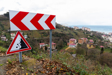 Mountain road road signs, dangerous turn and Falling rocks
