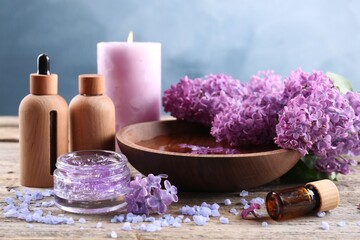 Fototapeta na wymiar Cosmetic products and lilac flowers on wooden table