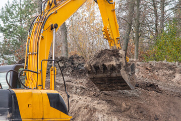 Fototapeta Digging soil with excavator. Close up of shovel of excavator with soil obraz