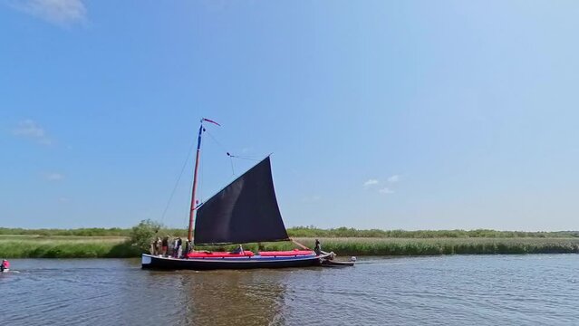 The traditional Norfolk wherry transporting passengers along the River Bure, Norfolk Broads. Captured on a bright summer day