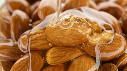 Nuts in honey. Pouring honey on almonds, close up
