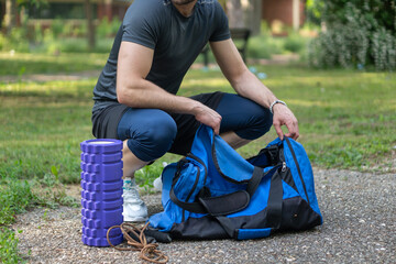 Fototapeta premium Man takes out sports equipment from gym bag. 