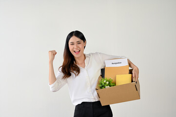 Excited and joyful Asian female office worker showing her fist, celebrating her resignation