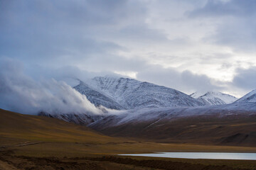 Fototapeta na wymiar snow covered mountains, cloudy sky at the way from Moriri lake to Leh city, Ladakh, India