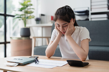 Asian accounting professional calculating household bills, reviewing and analyzing household bills, and filing tax returns