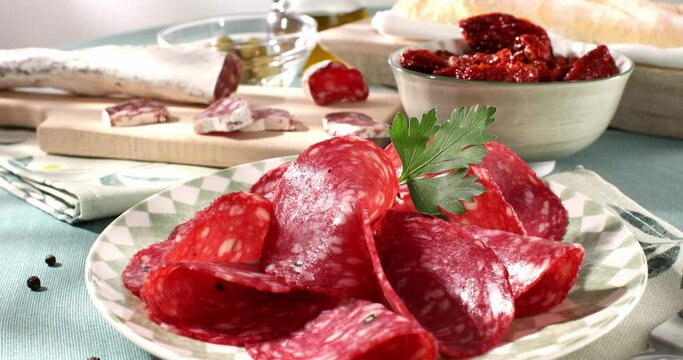 slices sausage salchichon on a plate. salami on a cutting board. cold cuts with bread and tomatoes. traditional spanish and italian sausages. meat delicacies antipasto on the table. 