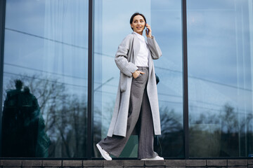 Business woman talking on the phone outside office bulding