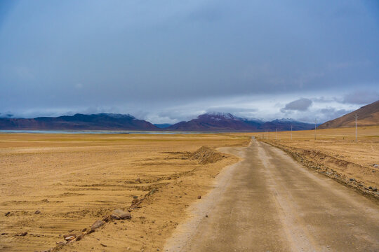withered grass field, snow covered mountains, cloudy sky at the way from Moriri lake to Leh city, Ladakh, India © Nhan