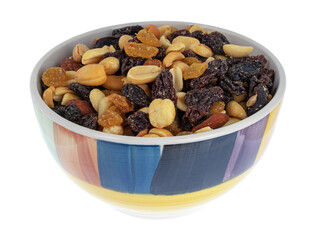 Side view of high energy trail mix with roasted nuts and fruit in a colorful bowl isolated on a white background.
