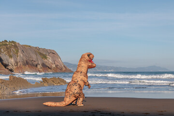 T-rex on the ocean beach in Zumaia, Spain. Dinosaur next to sea..