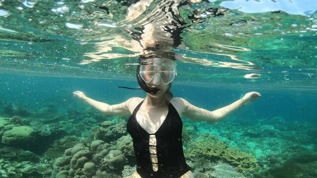 Snorkeling, blowing kiss and woman in ocean for adventure, holiday and vacation in Mauritius. Diving, travel and female person in tropical water with hand gesture to explore coral reef on island