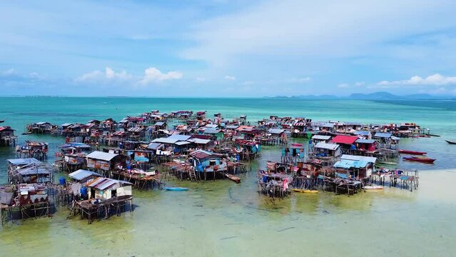 Revealing landscape drone shot of Pulau Omadal with Sea houses of the sea nomads. Water Village at Day, Sabah, Malaysia