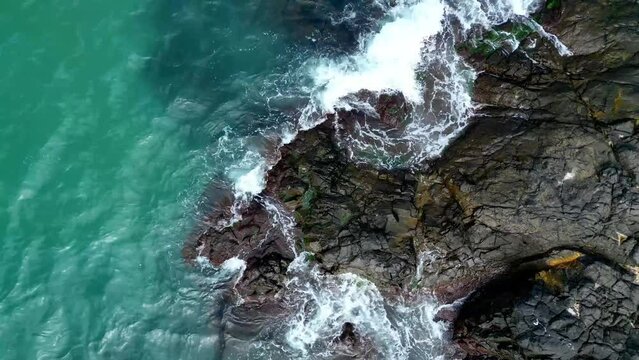 turquoise waves around the sea cliff top view - stock video from bird's eye view of a flying drone