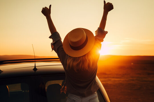 Happy girl celebrating success at sunset, The girl is wearing a hat and her arms are outstretched out of car