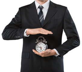 Businessman holding alarm clock against