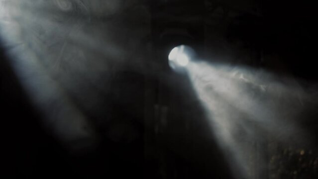 White stage lights creating rays of light through the smoke, slow motion