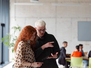 In a modern and spacious office a team of business colleagues are seen diligently working together, using a laptop to analyze data and statistics