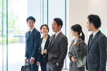 オフィスで会話するエグゼクティブビジネスパーソンのグループ