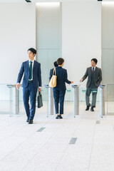 Group of business people walking in office building lobby.