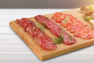 Prosciutto, salami snack on a wooden board.