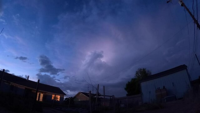 Dramatic lightning storm over a suburban neighborhood from dusk to darkness - nightscape time lapse