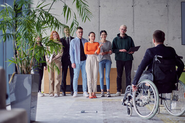 A group of diverse entrepreneurs gather in a modern office to discuss business ideas and strategies, while a colleague in a wheelchair joins them.