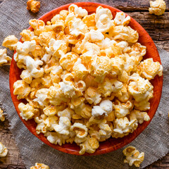 plate with popcorn on a napkin on a wooden background